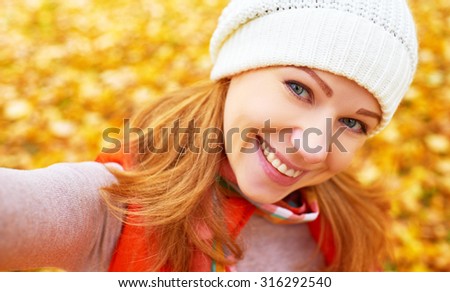 Selfie. beautiful woman photographing themselves outdoors in autumn