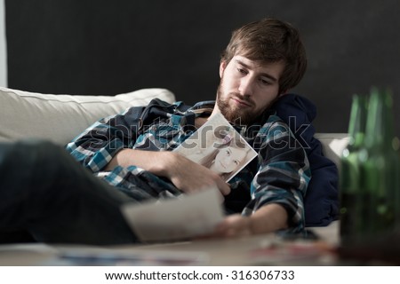 Devastated sad man with a photo of ex girlfriend