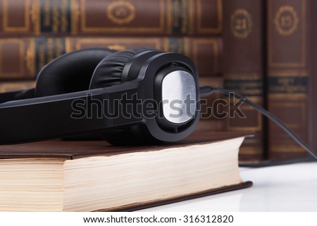Audiobooks concept. Old books and black headphones