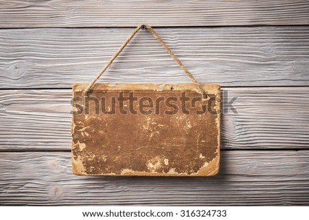 Aged cardboard plate over light wooden background
