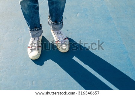 sneakers walking on blue floor,sneakers with shadow Royalty-Free Stock Photo #316340657
