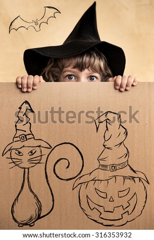 Funny child dressed witch costume. Halloween holidays concept