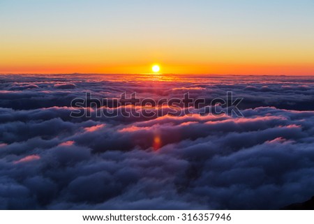 Beautiful sunset on the hill above clouds Royalty-Free Stock Photo #316357946