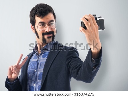 Vintage young man making a selfie over textured background