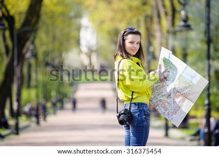 young girl with a map of walks in the park show way