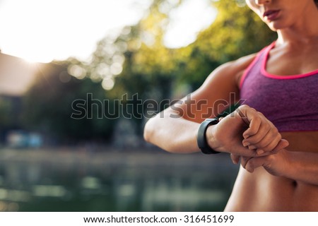 Woman setting up the fitness smart watch for running. Sportswoman checking watch device. Royalty-Free Stock Photo #316451699