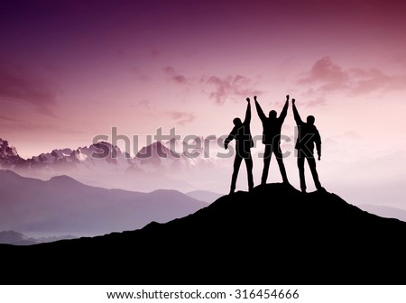 Silhouettes of team on mountain peak. Sport and active life concept

