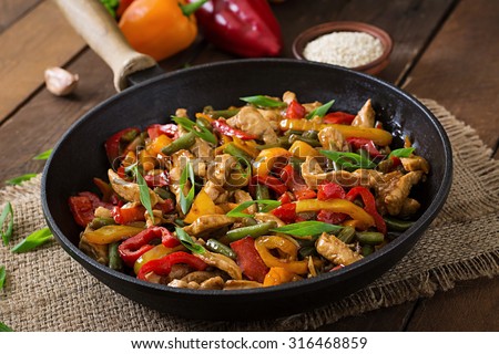 Stir fry chicken, sweet peppers and green beans Royalty-Free Stock Photo #316468859
