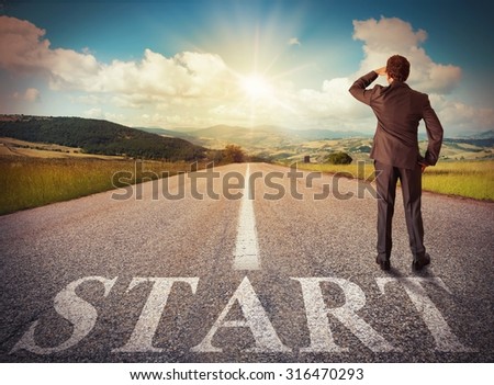 Businessman looks at the horizon from road