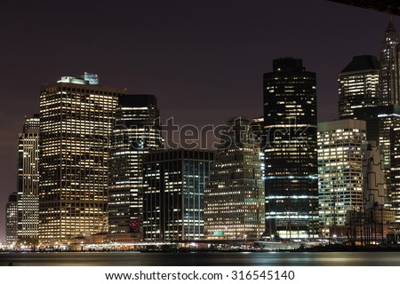 Close shot of skyscrapers with lights on in the offices by night, Manhattan, New York.