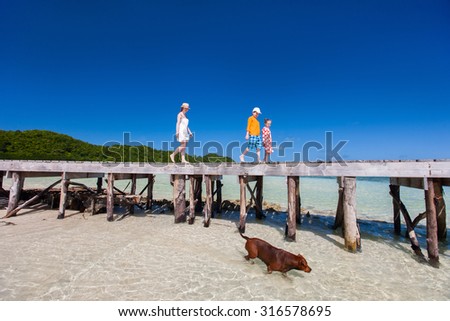 Mother and kids on a tropical beach enjoying summer vacation