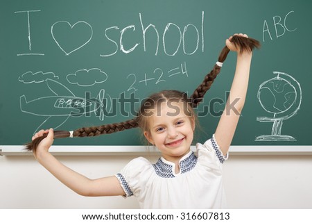 girl with pigtail drawing object on school board