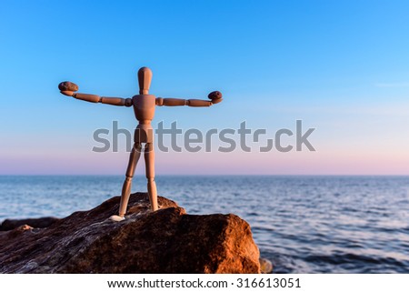 Stones in the hands of a wooden mannequin
