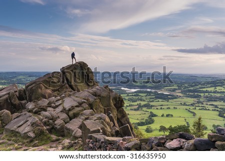 A climber at the roaches with a view over Tittisworth, Peak District National Park Royalty-Free Stock Photo #316635950