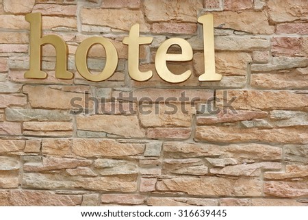 Hotel Sign On Artificial Stone Wall Background. Vacation Concept