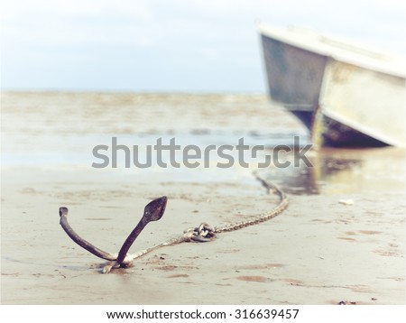 anchored on the shore with boat in the background