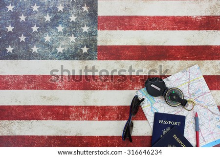 Map, compass, passports and sunglasses on vintage American flag canvas background