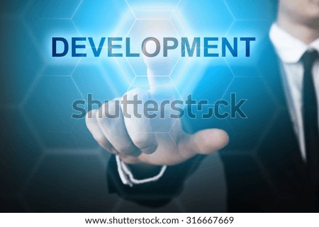 Businessman pressing touch screen interface and select "development". 