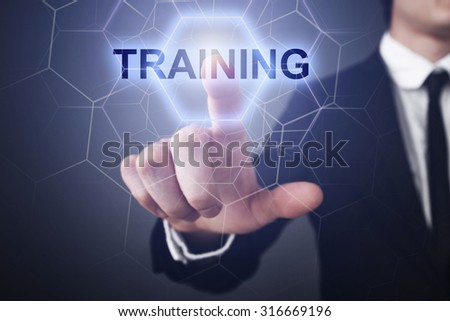 Businessman pressing button on touch screen interface and select "training". 
