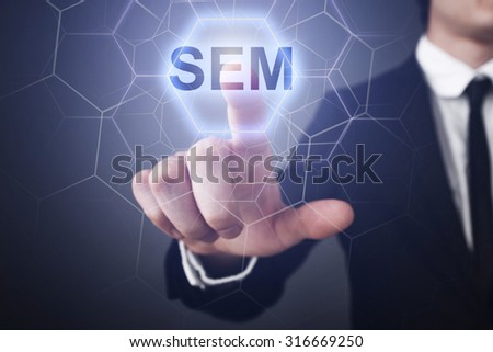 Businessman pressing button on touch screen interface and select "sem". 