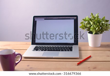 Laptop stands on a wooden table