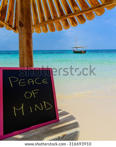 In the picture a Zanzibar beach which is a small blackboard with the words " Peace of mind" in the afternoon .