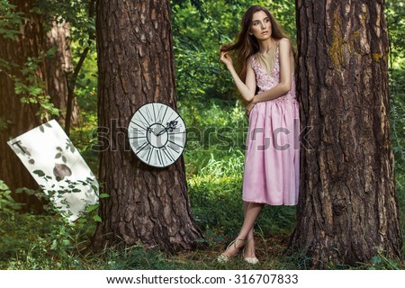 cute girl in pink dress in the woods