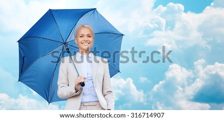 business, weather, season and people and concept - young smiling businesswoman with umbrella over blue sky and clouds background