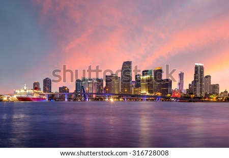 Miami city skyline panorama at twilight with urban skyscrapers and bridge USA