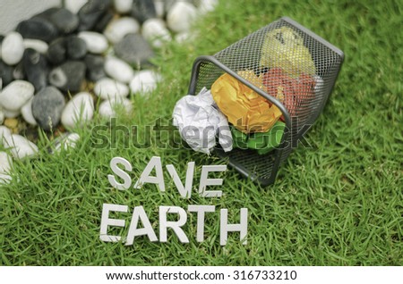top view of colorful  ball waste paper on garbage can. word SAVE EARTH on green grass.bokeh and blurred image