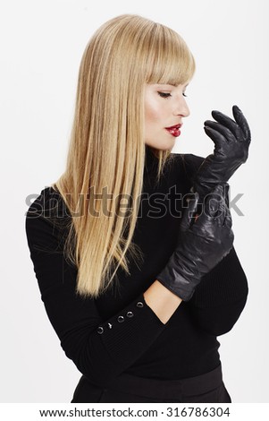 Beautiful woman with black gloves on in studio