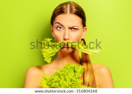Pretty cheerful young woman posing with fresh green lettuce leaves. Healthy eating concept. Dieting. Royalty-Free Stock Photo #316804268