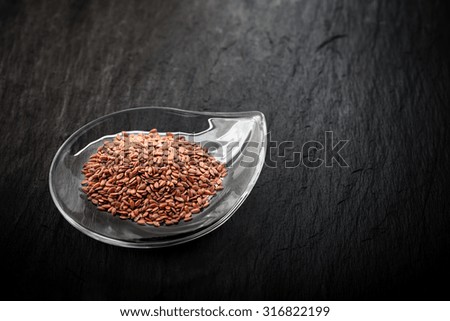 Flax seed in glass bowl a stone plate