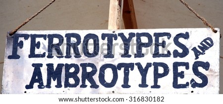Vintage ferrotypes and ambrotypes sign displayed outside for old time photography.