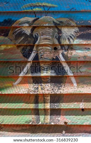 Elephant mural on wooden shack in sunshine