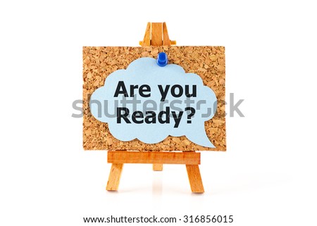Wooden easel with corkboard and blue speech bubble with words Are You Ready? isolated on white background