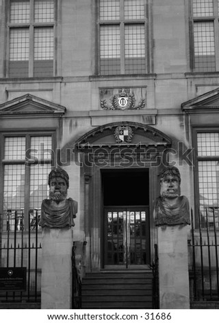 Entrance to building with gargoyles photo is in black and white
