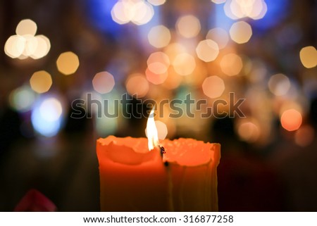 burning candle with bokeh blur in the background