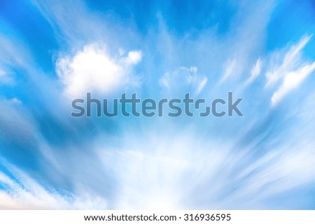 Sun rays shining through the blue clouds at sunset