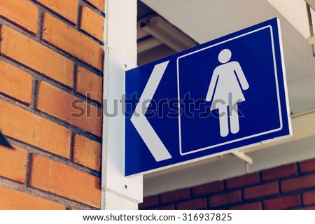 restroom signs with female symbol and arrow direction signs