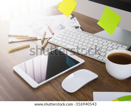Modern office workplace with digital tablet, notepad, colorful pencils, glasses, in morning