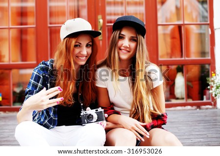 Group of friends shopping together. Concept about consumerism, shopping, friendship and people. Retro photographer. Modern urban girls has fun with vintage photo camera outdoor 