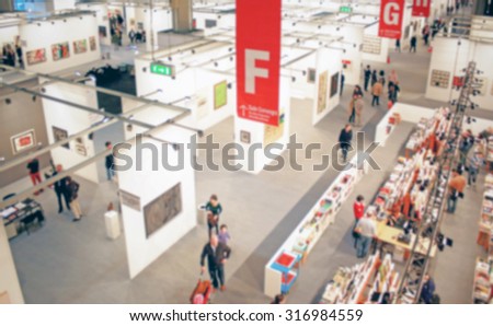 People visiting an art exhibition, generic background, intentionally blurred post production.