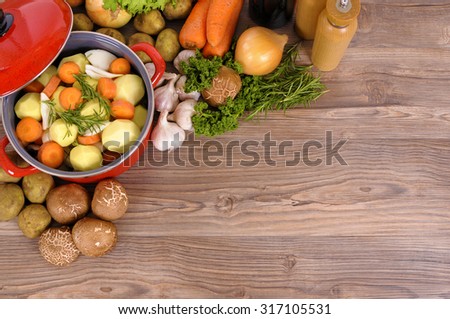 Casserole dish or stew pot, vegetables and herbs, copy space. Royalty-Free Stock Photo #317105531