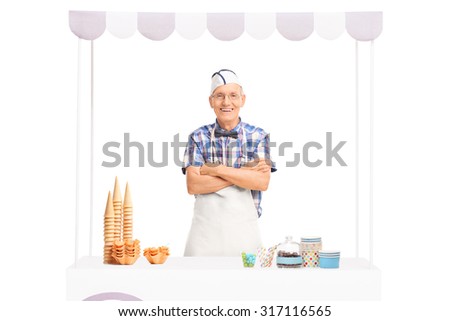Mature ice cream vendor standing behind a kiosk and looking at the camera isolated on white background