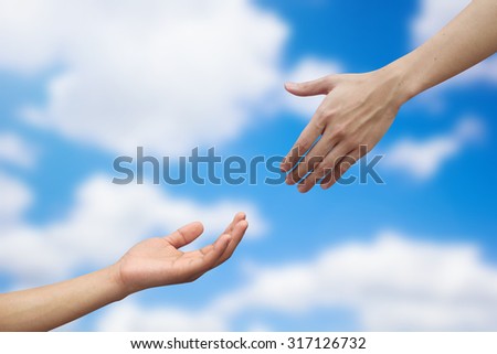 close up human hand helping and praying hand on blurred sky background for support concept 