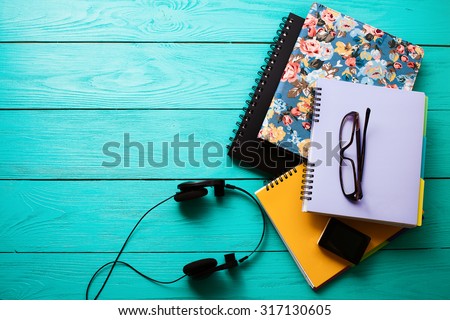 Teen workspace on blue wooden background. Top view Royalty-Free Stock Photo #317130605