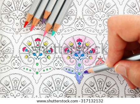 image of woman coloring, adult coloring book trend, for stress relief.  top view