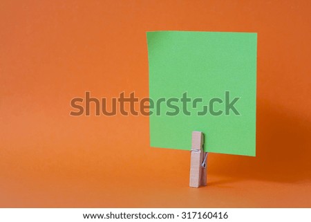 paper notes and clothespins isolated on orange background
