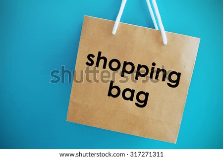 Brown paper shopping bag on blue background.
